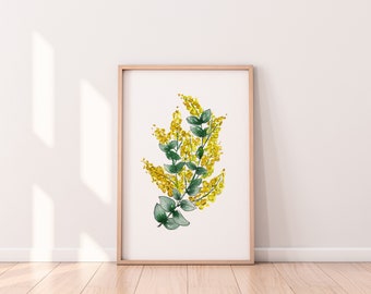May include: A framed watercolor painting of a yellow flower with green leaves. The painting is on a white background and is framed in a light wood frame.