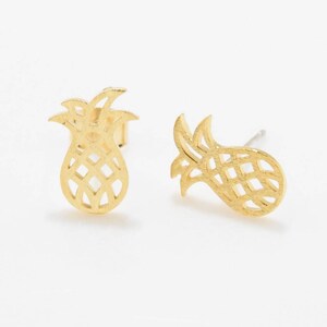 May include: A pair of gold pineapple-shaped stud earrings. The earrings are made of a delicate metal and have a cutout design.