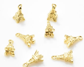 May include: Eight gold-colored Eiffel Tower charms with a loop for hanging. The charms are small and detailed.