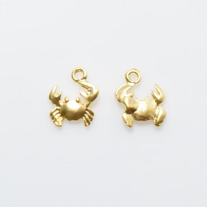 May include: Two gold-colored crab charms with a loop at the top for attaching to jewelry or other crafts.