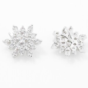 May include: A pair of silver snowflake earrings with clear cubic zirconia stones.