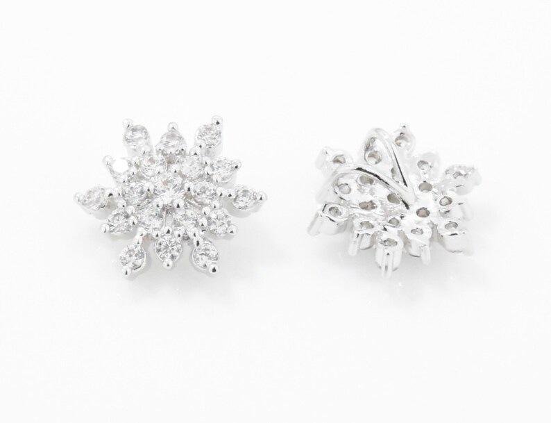 May include: A pair of silver snowflake earrings with clear cubic zirconia stones.