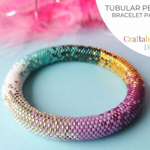 May include: A tubular peyote bracelet pattern by Craftaholique Designs. The beaded bracelet features a gradient of colors, including white, teal, gold, and pink. The bracelet is made of small, colorful beads. The text "TUBULAR PEYOTE BRACELET PATTERN" is visible.