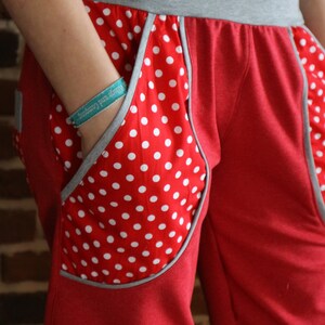 May include: Red sweatpants with a white polka dot pocket detail and a gray waistband.