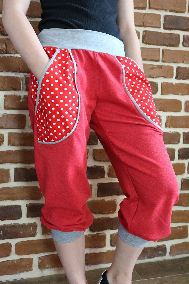 May include: Red capri pants with grey trim and white polka dot fabric accents on the pockets.