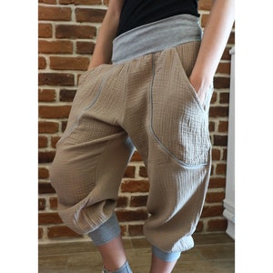 May include: Beige cropped pants with large pockets and a grey waistband.