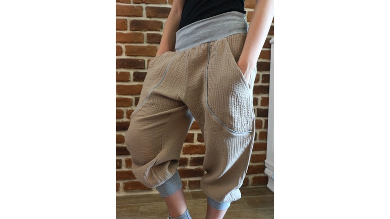 May include: Beige cropped pants with large pockets and a grey waistband.