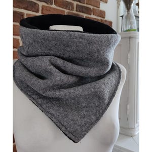 May include: A grey and black fleece neck warmer. The neck warmer is folded and has a triangular shape.