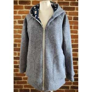 May include: A grey hooded jacket with a zip fastening and a patterned lining. The jacket has two pockets on the front.