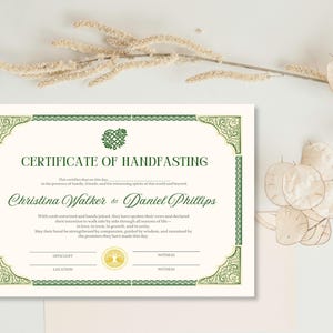 Könnte beinhalten: Eine Handfasting-Urkunde mit grünen dekorativen Rändern und Text. Die Urkunde enthält die Namen Christina Walker & Daniel Phillips. Die Urkunde befindet sich auf einem weißen Hintergrund mit getrockneten floralen Akzenten.