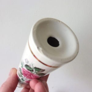 A pair of tall ceramic salt and pepper shakers with gold trim and rose transfers.