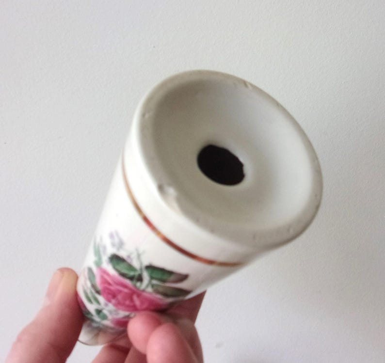 A pair of tall ceramic salt and pepper shakers with gold trim and rose transfers.