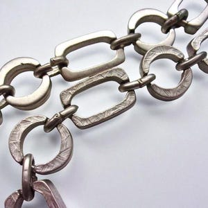 Close-up of a Brutalist Necklace featuring a Steel Link Chain and Geometric Choker design. This Industrial Style piece showcases Sculptural Steel with a bold Architectural Look, ideal for Urban Jewelry UK collectors. A Statement Chain and Unisex Necklace, it’s a Sustainable Gift and perfect Gift for Him. Inspired by MCM Revival, this Bold Steel Piece blends raw texture with timeless edge.