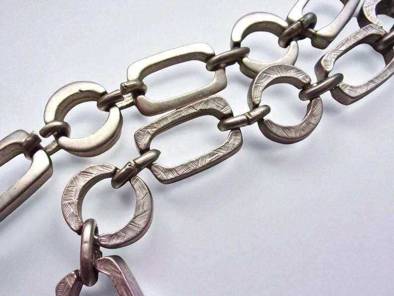 Close-up of a Brutalist Necklace featuring a Steel Link Chain and Geometric Choker design. This Industrial Style piece showcases Sculptural Steel with a bold Architectural Look, ideal for Urban Jewelry UK collectors. A Statement Chain and Unisex Necklace, it’s a Sustainable Gift and perfect Gift for Him. Inspired by MCM Revival, this Bold Steel Piece blends raw texture with timeless edge.