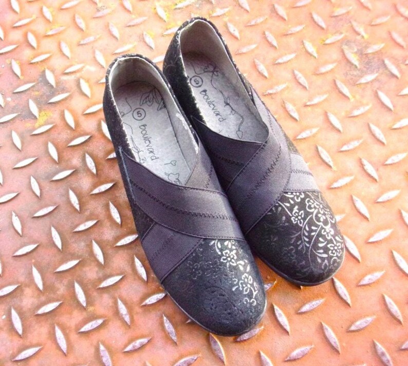 A pair of black suede wedges with floral wedge heels and damask print shoes detailing, crafted as eco leather flats in UK size 5 shoes. These arch support shoes offer comfort for daily wear, styled as casual black flats or editorial loafers. Designed as a walking comfort shoe, they feature soft sole wedges and reflect handmade footwear values. A perfect slow fashion gift, ideal for collectors of vintage style shoes.