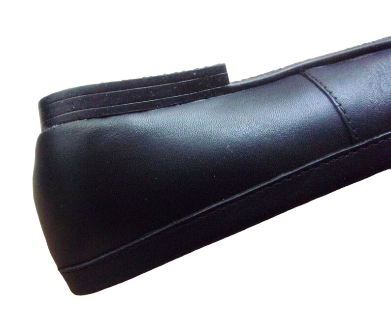 A pair of Vintage Loafers styled as Black Leather Loafers with a bow detail, these 1980s Leather Flats are timeless Bow Detail Loafers made from Soft Leather Shoes. Perfect as Retro Work Shoes, Minimalist Loafers, or Office Leather Flats, they channel Preppy Style Shoes and Quiet Luxury. Designed as Gender Neutral Shoes, they reflect Archive Fashion values and sustainable elegance in classic Leather Slip Ons.