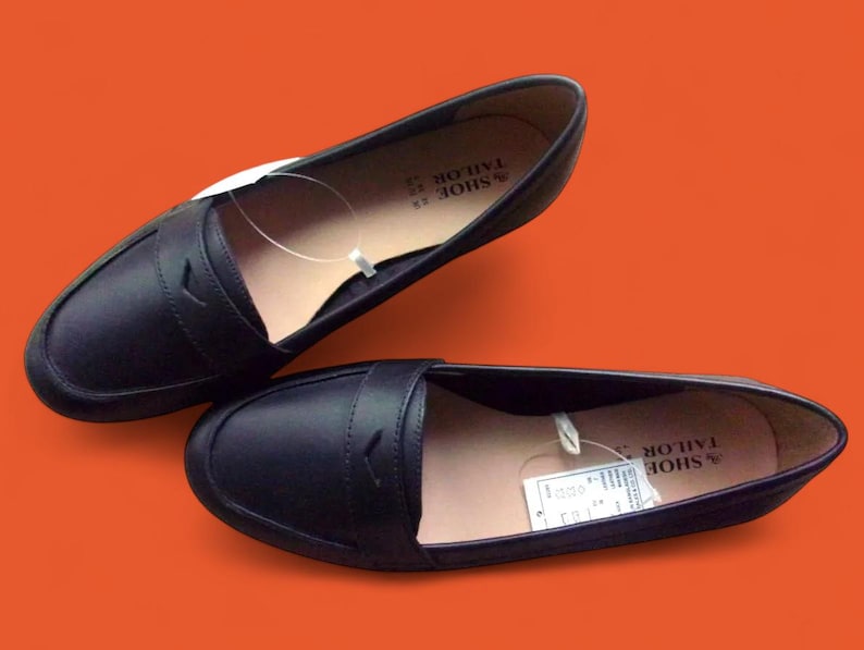 A pair of Vintage Loafers styled as Black Leather Loafers with a bow detail, these 1980s Leather Flats are timeless Bow Detail Loafers made from Soft Leather Shoes. Perfect as Retro Work Shoes, Minimalist Loafers, or Office Leather Flats, they channel Preppy Style Shoes and Quiet Luxury. Designed as Gender Neutral Shoes, they reflect Archive Fashion values and sustainable elegance in classic Leather Slip Ons.
