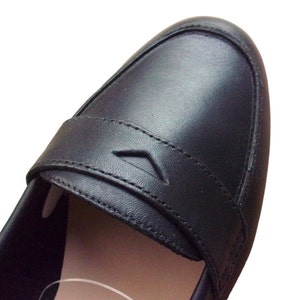 A pair of Vintage Loafers styled as Black Leather Loafers with a bow detail, these 1980s Leather Flats are timeless Bow Detail Loafers made from Soft Leather Shoes. Perfect as Retro Work Shoes, Minimalist Loafers, or Office Leather Flats, they channel Preppy Style Shoes and Quiet Luxury. Designed as Gender Neutral Shoes, they reflect Archive Fashion values and sustainable elegance in classic Leather Slip Ons.
