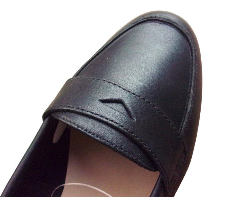 A pair of Vintage Loafers styled as Black Leather Loafers with a bow detail, these 1980s Leather Flats are timeless Bow Detail Loafers made from Soft Leather Shoes. Perfect as Retro Work Shoes, Minimalist Loafers, or Office Leather Flats, they channel Preppy Style Shoes and Quiet Luxury. Designed as Gender Neutral Shoes, they reflect Archive Fashion values and sustainable elegance in classic Leather Slip Ons.