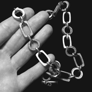Close-up of a Brutalist Necklace featuring a Steel Link Chain and Geometric Choker design. This Industrial Style piece showcases Sculptural Steel with a bold Architectural Look, ideal for Urban Jewelry UK collectors. A Statement Chain and Unisex Necklace, it’s a Sustainable Gift and perfect Gift for Him. Inspired by MCM Revival, this Bold Steel Piece blends raw texture with timeless edge.