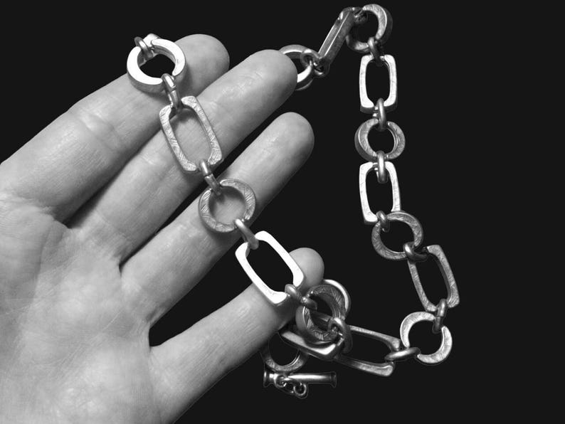 Close-up of a Brutalist Necklace featuring a Steel Link Chain and Geometric Choker design. This Industrial Style piece showcases Sculptural Steel with a bold Architectural Look, ideal for Urban Jewelry UK collectors. A Statement Chain and Unisex Necklace, it’s a Sustainable Gift and perfect Gift for Him. Inspired by MCM Revival, this Bold Steel Piece blends raw texture with timeless edge.
