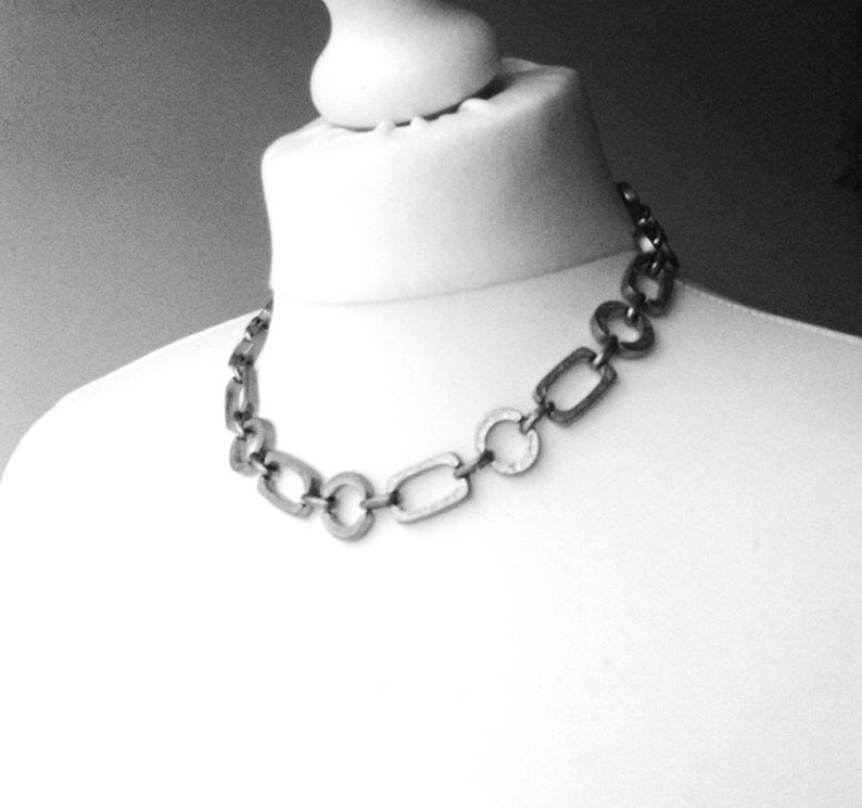 Close-up of a Brutalist Necklace featuring a Steel Link Chain and Geometric Choker design. This Industrial Style piece showcases Sculptural Steel with a bold Architectural Look, ideal for Urban Jewelry UK collectors. A Statement Chain and Unisex Necklace, it’s a Sustainable Gift and perfect Gift for Him. Inspired by MCM Revival, this Bold Steel Piece blends raw texture with timeless edge.