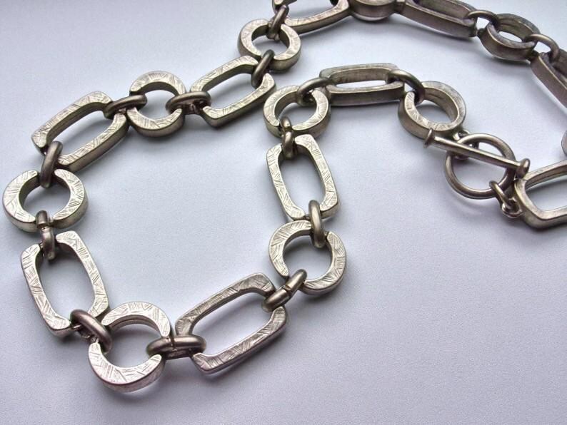 Close-up of a Brutalist Necklace featuring a Steel Link Chain and Geometric Choker design. This Industrial Style piece showcases Sculptural Steel with a bold Architectural Look, ideal for Urban Jewelry UK collectors. A Statement Chain and Unisex Necklace, it’s a Sustainable Gift and perfect Gift for Him. Inspired by MCM Revival, this Bold Steel Piece blends raw texture with timeless edge.
