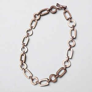 Close-up of a Brutalist Necklace featuring a Steel Link Chain and Geometric Choker design. This Industrial Style piece showcases Sculptural Steel with a bold Architectural Look, ideal for Urban Jewelry UK collectors. A Statement Chain and Unisex Necklace, it’s a Sustainable Gift and perfect Gift for Him. Inspired by MCM Revival, this Bold Steel Piece blends raw texture with timeless edge.
