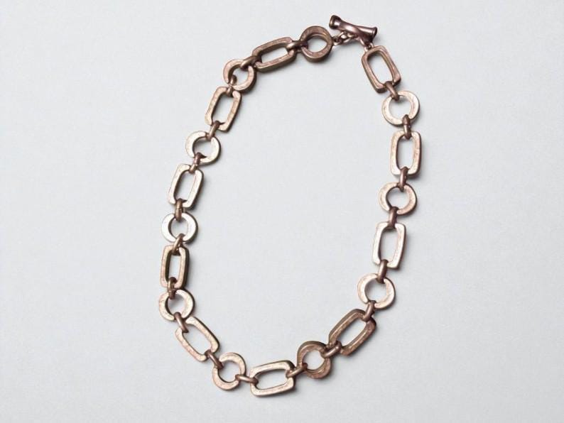 Close-up of a Brutalist Necklace featuring a Steel Link Chain and Geometric Choker design. This Industrial Style piece showcases Sculptural Steel with a bold Architectural Look, ideal for Urban Jewelry UK collectors. A Statement Chain and Unisex Necklace, it’s a Sustainable Gift and perfect Gift for Him. Inspired by MCM Revival, this Bold Steel Piece blends raw texture with timeless edge.