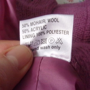 Lilac mohair oversized cardigan with textured knit and buttons worn with a black skirt.