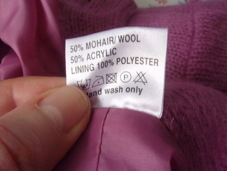 Lilac mohair oversized cardigan with textured knit and buttons worn with a black skirt.