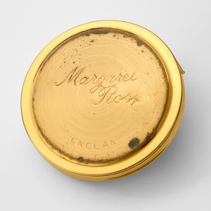 A small vintage pillbox with a red-and-ivory cameo trinket framed in gold filigree, this gold keepsake doubles as a mini treasure and handmade box. Styled as a regency charm, it’s perfect for gifting as a victorian gift or historical gift. The aged finish enhances its appeal as an antique case, ideal for retro cottage collectors seeking micro luxury and collectible art in a timeless rose gold box.
