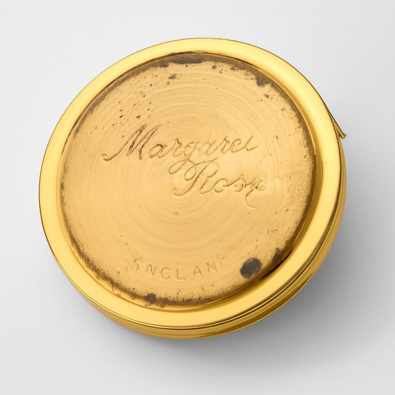 A small vintage pillbox with a red-and-ivory cameo trinket framed in gold filigree, this gold keepsake doubles as a mini treasure and handmade box. Styled as a regency charm, it’s perfect for gifting as a victorian gift or historical gift. The aged finish enhances its appeal as an antique case, ideal for retro cottage collectors seeking micro luxury and collectible art in a timeless rose gold box.