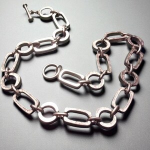 Close-up of a Brutalist Necklace featuring a Steel Link Chain and Geometric Choker design. This Industrial Style piece showcases Sculptural Steel with a bold Architectural Look, ideal for Urban Jewelry UK collectors. A Statement Chain and Unisex Necklace, it’s a Sustainable Gift and perfect Gift for Him. Inspired by MCM Revival, this Bold Steel Piece blends raw texture with timeless edge.