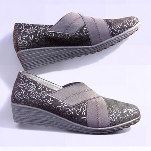 A pair of black suede wedges with floral wedge heels and damask print shoes detailing, crafted as eco leather flats in UK size 5 shoes. These arch support shoes offer comfort for daily wear, styled as casual black flats or editorial loafers. Designed as a walking comfort shoe, they feature soft sole wedges and reflect handmade footwear values. A perfect slow fashion gift, ideal for collectors of vintage style shoes.
