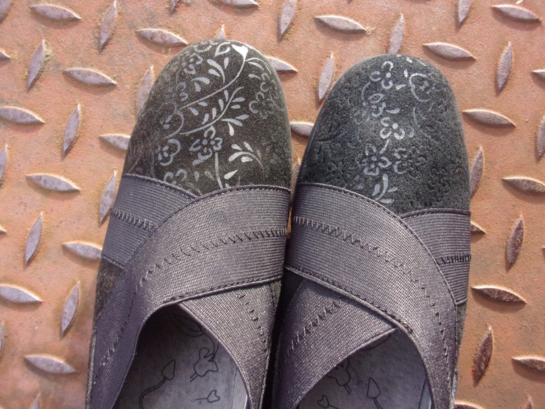 A pair of black suede wedges with floral wedge heels and damask print shoes detailing, crafted as eco leather flats in UK size 5 shoes. These arch support shoes offer comfort for daily wear, styled as casual black flats or editorial loafers. Designed as a walking comfort shoe, they feature soft sole wedges and reflect handmade footwear values. A perfect slow fashion gift, ideal for collectors of vintage style shoes.
