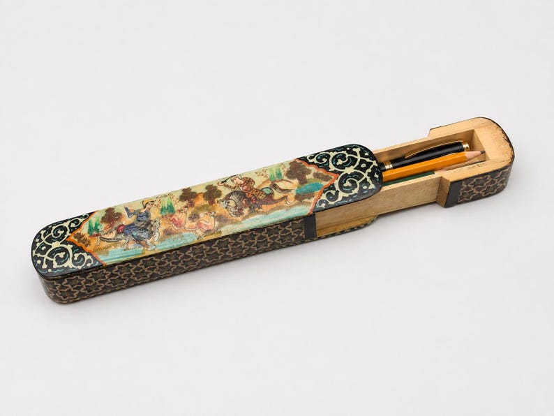 Handcrafted Persian miniature desk box with sliding compartment holding a pen and pencil, photographed in a light grey studio to highlight its vintage marquetry craftsmanship.