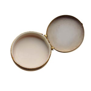 A small vintage pillbox with a red-and-ivory cameo trinket framed in gold filigree, this gold keepsake doubles as a mini treasure and handmade box. Styled as a regency charm, it’s perfect for gifting as a victorian gift or historical gift. The aged finish enhances its appeal as an antique case, ideal for retro cottage collectors seeking micro luxury and collectible art in a timeless rose gold box.