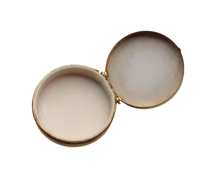 A small vintage pillbox with a red-and-ivory cameo trinket framed in gold filigree, this gold keepsake doubles as a mini treasure and handmade box. Styled as a regency charm, it’s perfect for gifting as a victorian gift or historical gift. The aged finish enhances its appeal as an antique case, ideal for retro cottage collectors seeking micro luxury and collectible art in a timeless rose gold box.