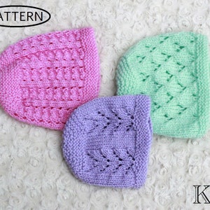 May include: Three knitted hats in pink, light green, and purple. The hats have a lacy pattern and are arranged on a white fluffy surface. The word "PATTERN" is visible in a black oval in the upper left corner of the image. The letters "KH" are visible in the lower right corner of the image.