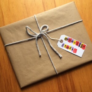 May include: A brown paper package tied with twine and a gift tag that says "Granville Studio" in colorful letters.