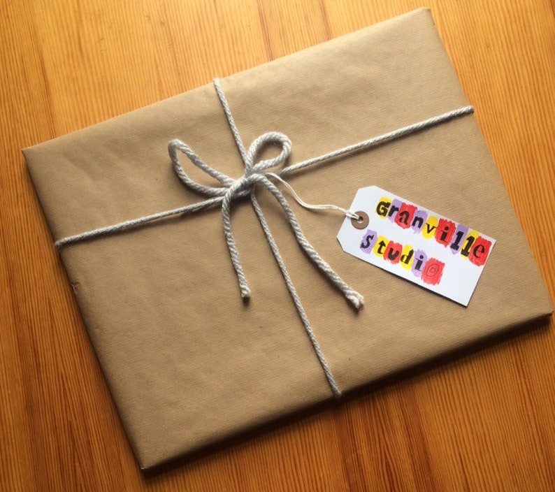 May include: A brown paper package tied with twine and a gift tag that says "Granville Studio" in colorful letters.