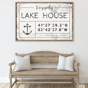 May include: A rectangular wall sign with a distressed white finish and a thin wooden frame. The text reads Kennedy LAKE HOUSE, featuring a black anchor graphic, coordinates 41°27'29.2"N 82°42'37.8"W, and the text ESTABLISHED 2008 in black ink.
