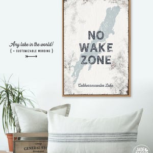 The No Wake Zone with a dusty blue lake silhouette print displayed near decorative pillows.