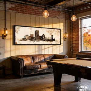 a cozy living room with a pool table, a leather couch, and a large framed artwork depicting a city skyline.