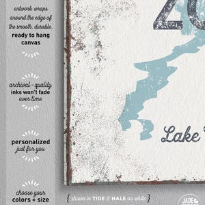A close-up of the print on a textured gray canvas background, reading a lake name in cursive script.