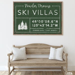 a wooden bench with two pillows, and above it is a framed sign with text and a graphic of trees.