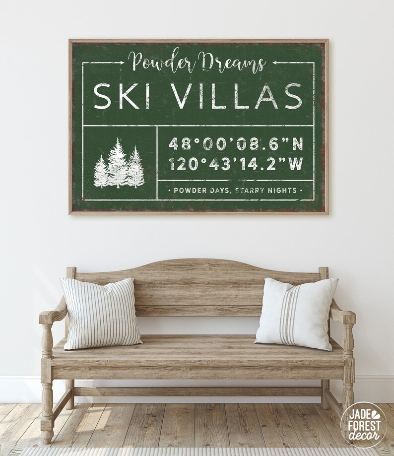 a wooden bench with two pillows, and above it is a framed sign with text and a graphic of trees.