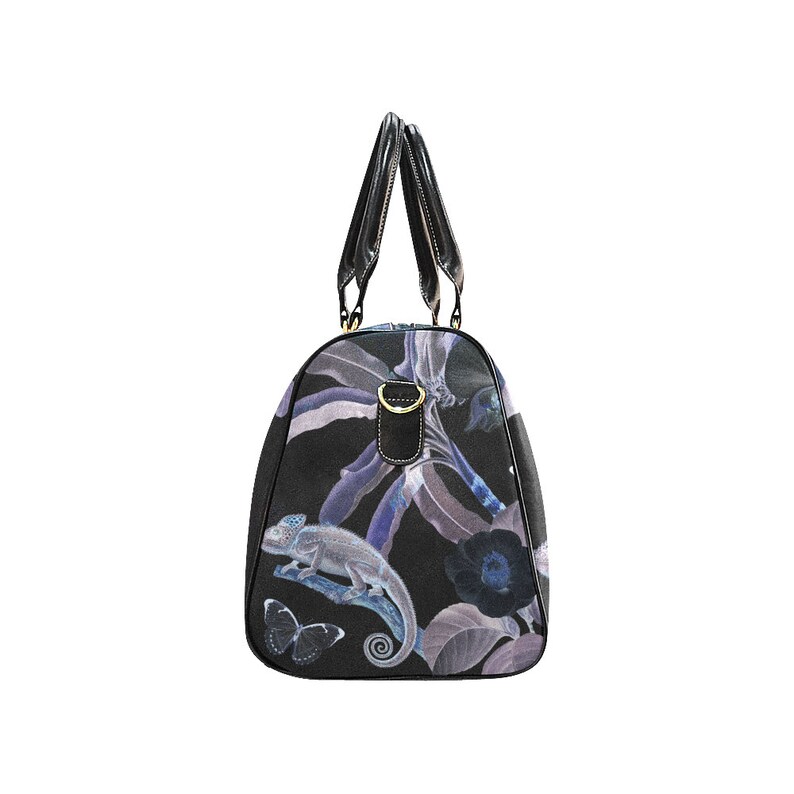 May include: Black travel bag with a floral print featuring a chameleon, butterflies, and leaves in shades of purple and blue.