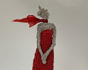Slim sculpture made of paper mache with a red coat in the wind, human, art, unique